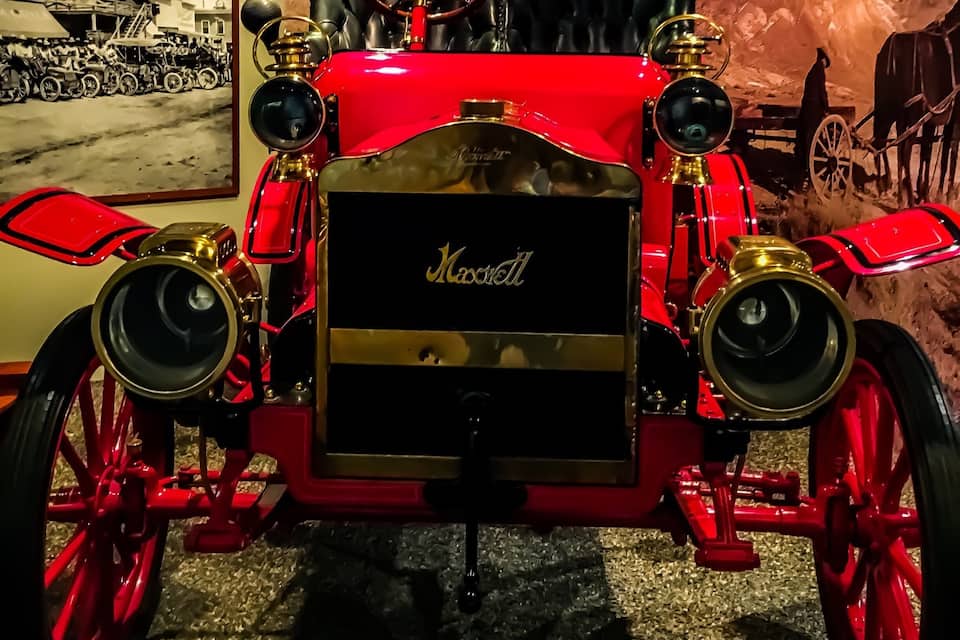 Un coche clásico rojo con detalles dorados y la palabra "Marshall" en la parte frontal.