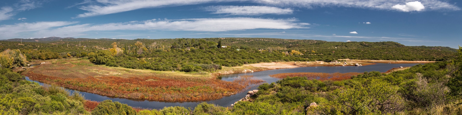 Paisagem costeira com rio, áreas pantanosas e vegetação densa.