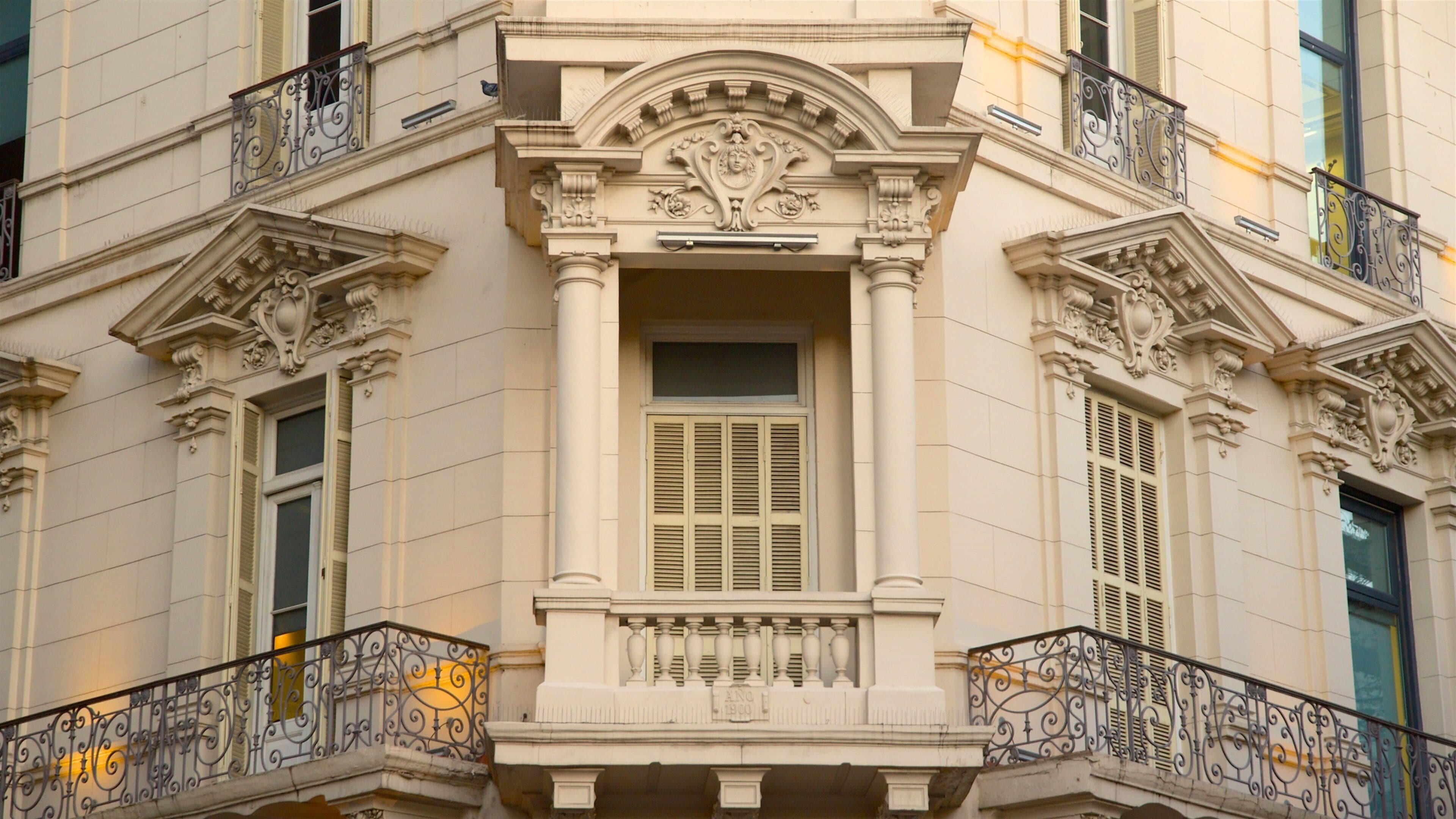 A classical building facade with ornate balconies and decorative moldings.