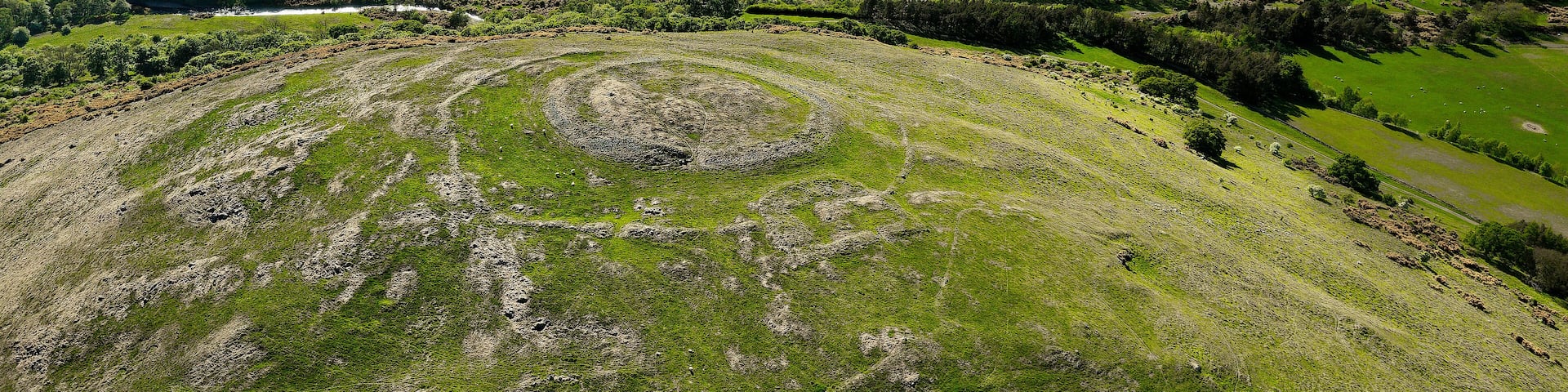 West Hill Camp prehistoric site, Kirknewton, Northumberland. Early palisade trench then Iron Age rampart settlement then Romano-British. View to West