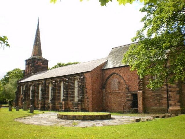 A historic church with a tall spire and arched windows.
