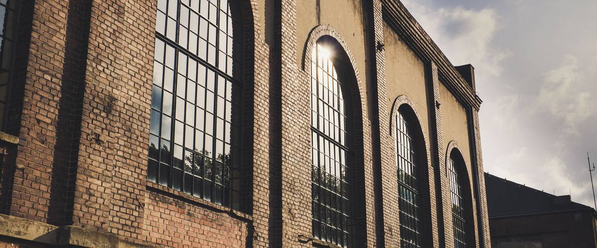 A large brick building with arched windows and a clear sky.