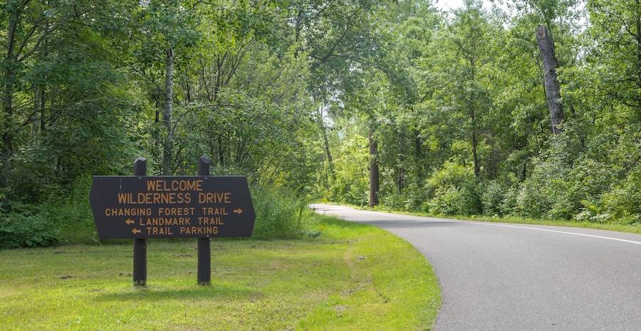 Wooden welcome and directional sign for the Wilderness Drive in the Itasca State Park in Minnesota.