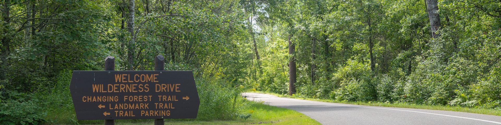 Wooden welcome and directional sign for the Wilderness Drive in the Itasca State Park in Minnesota.