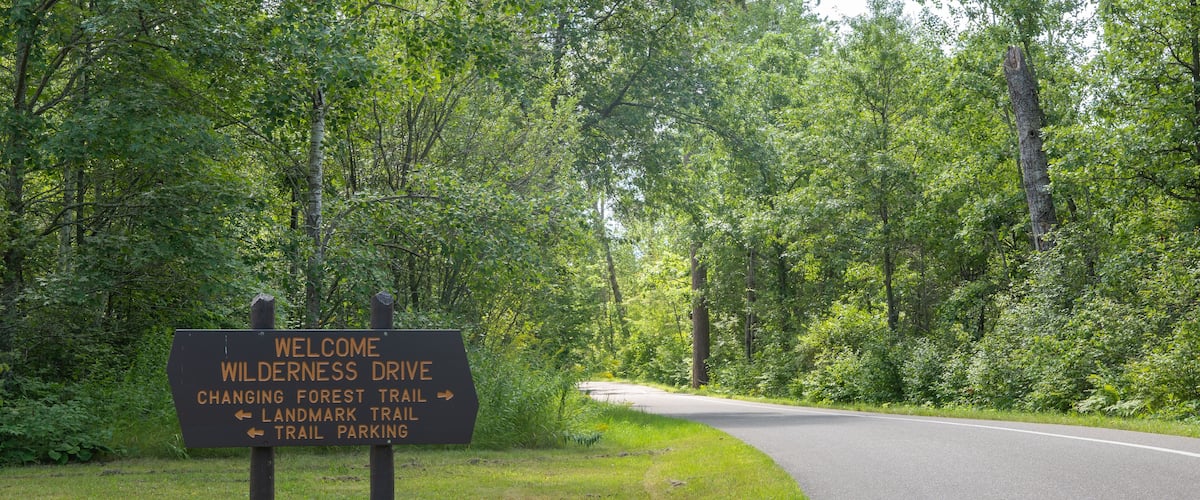 Wooden welcome and directional sign for the Wilderness Drive in the Itasca State Park in Minnesota.