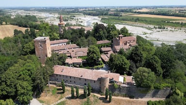 An aerial view of a historic town with a prominent tower, surrounded by fields and a river.