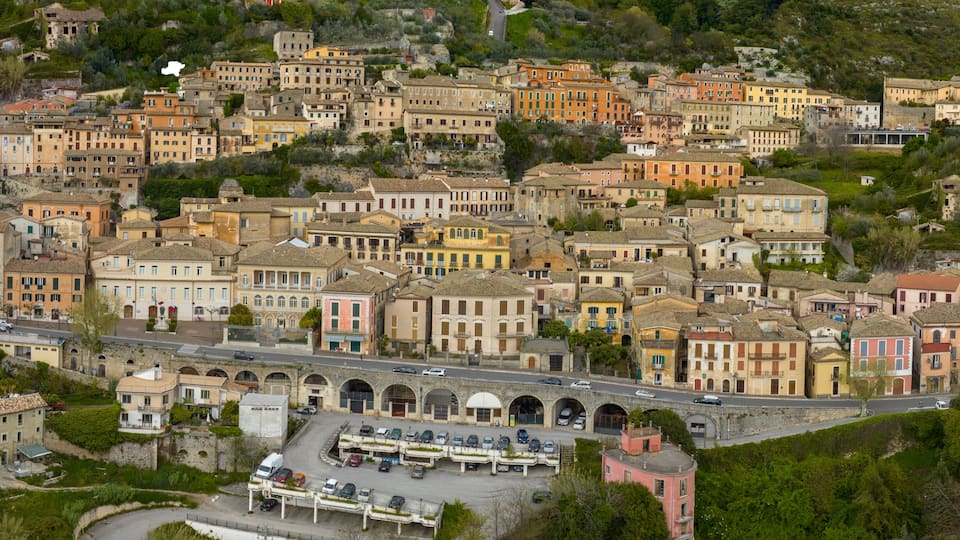 A densely packed hillside town with historic buildings and a central road.