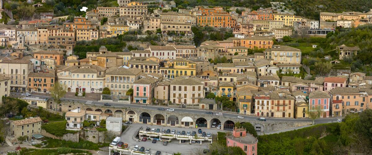 A densely packed hillside town with historic buildings and a central road.
