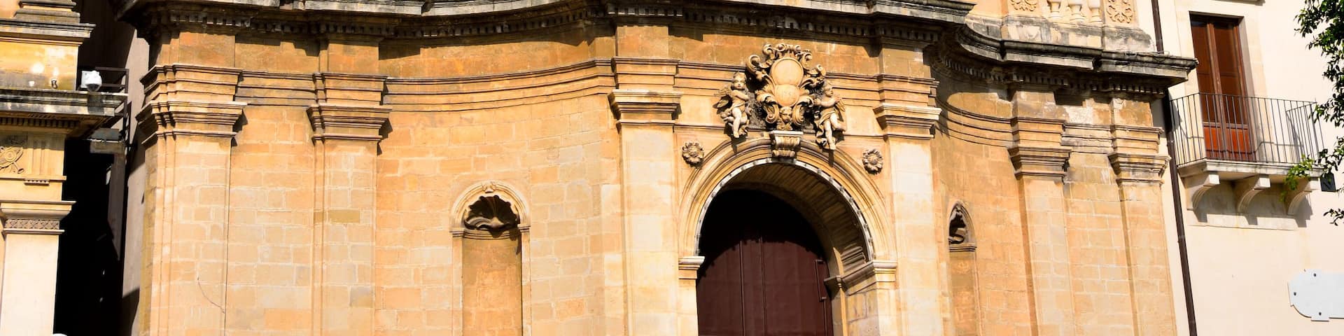A historic church with a bell tower, ornate carvings, and a large clock.
