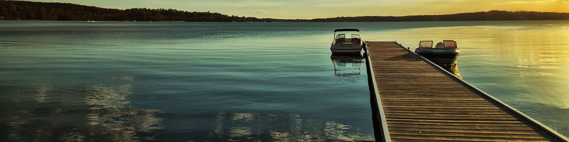 Motor boats moored on a jetty on Lake Macquarie, Australia at sunset
