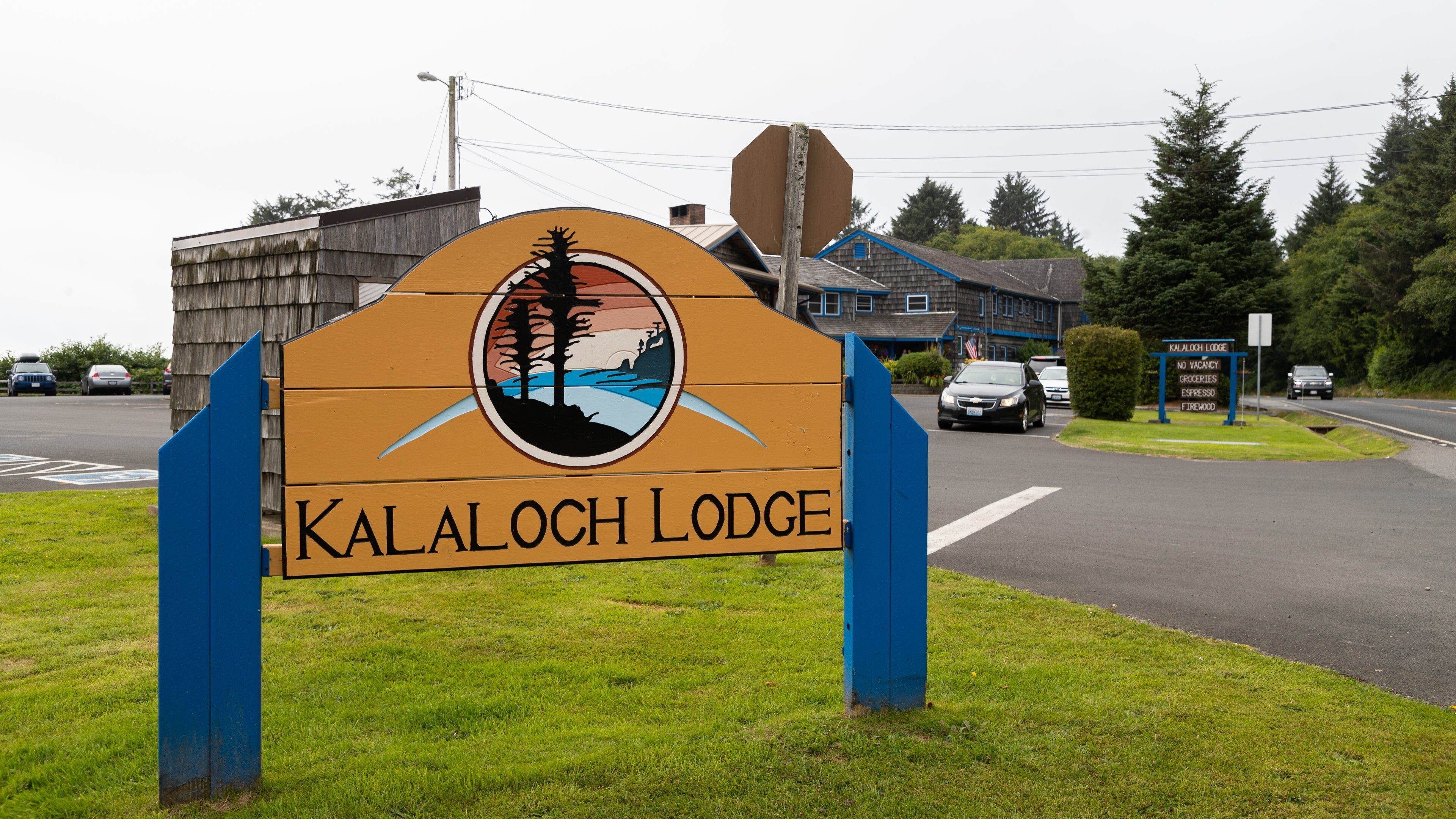 A sign for Kalaloch Lodge with a mountain and forest illustration.
