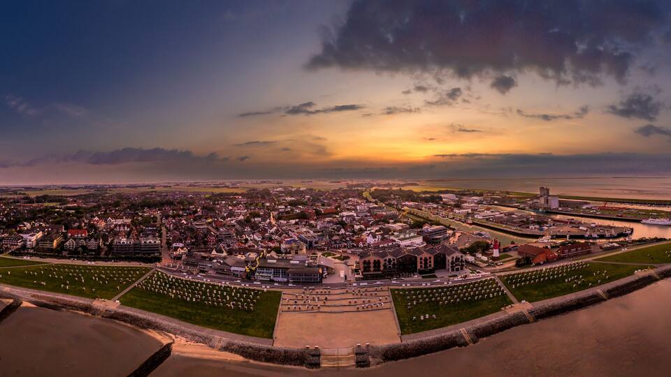 A coastal city with a large cemetery, a harbor, and a prominent lighthouse.