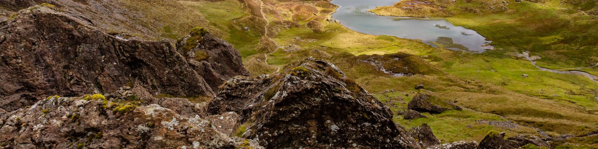 A mountainous landscape with a lake and a winding path.