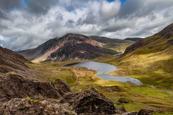 A mountainous landscape with a lake and a winding path.