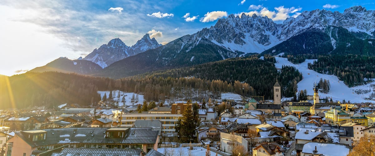 A snow-covered mountain range with a town nestled at its base.