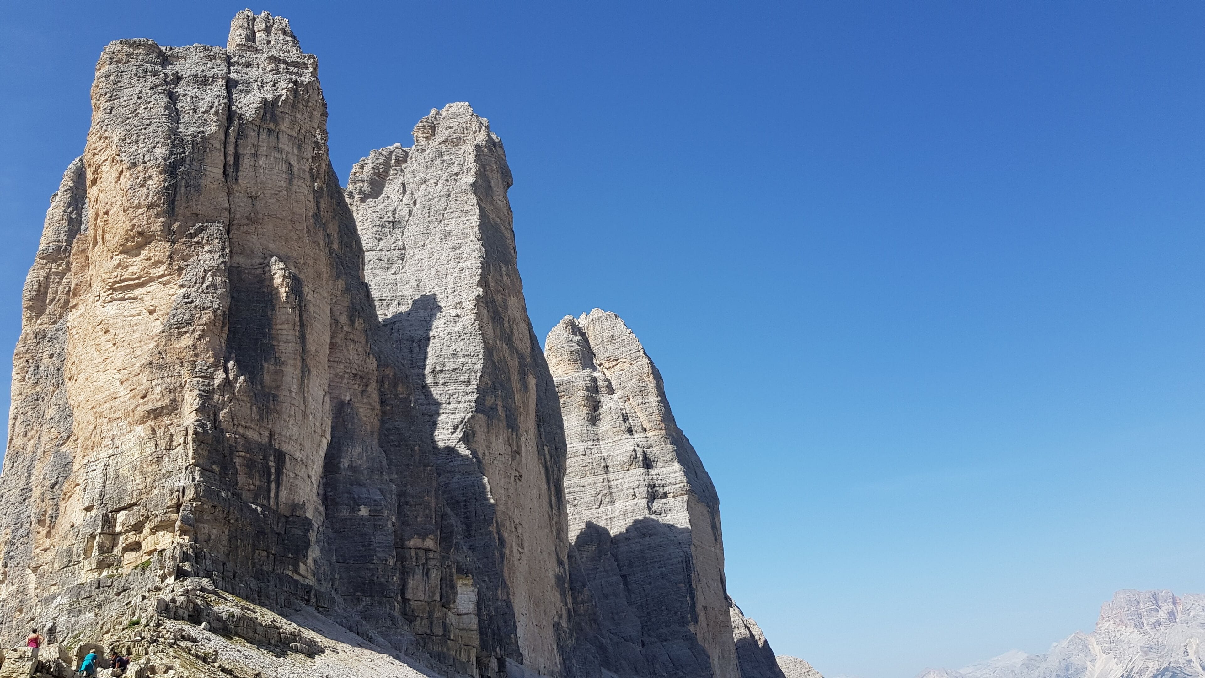 A mountain range with prominent rock formations under a clear blue sky.