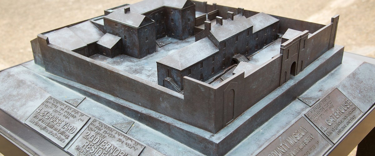 A detailed metal model of a historical building complex, including plaques with inscriptions.