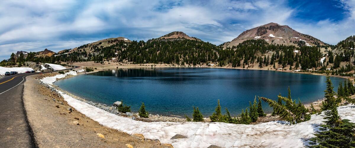 panoramic shot of turquiose blue Lake Helen in Lassen Volcano National Park in Northern California on a clear blue summer sky