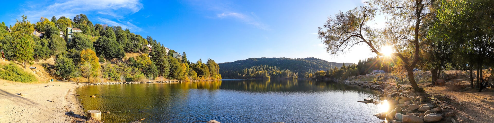 A calm lake surrounded by trees and hills.