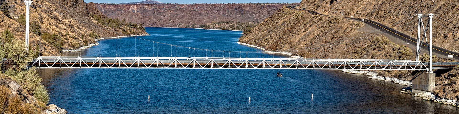 The one-lane bridge spans the Deschutes River flowing between steep basalt cliffs at Cove Palisades State Park, Oregon, USA