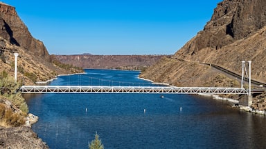 The one-lane bridge spans the Deschutes River flowing between steep basalt cliffs at Cove Palisades State Park, Oregon, USA
