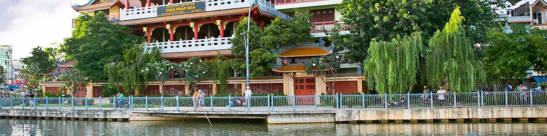 A traditional Chinese building with a multi-tiered roof, a reflection in the water, and a bridge in the foreground.