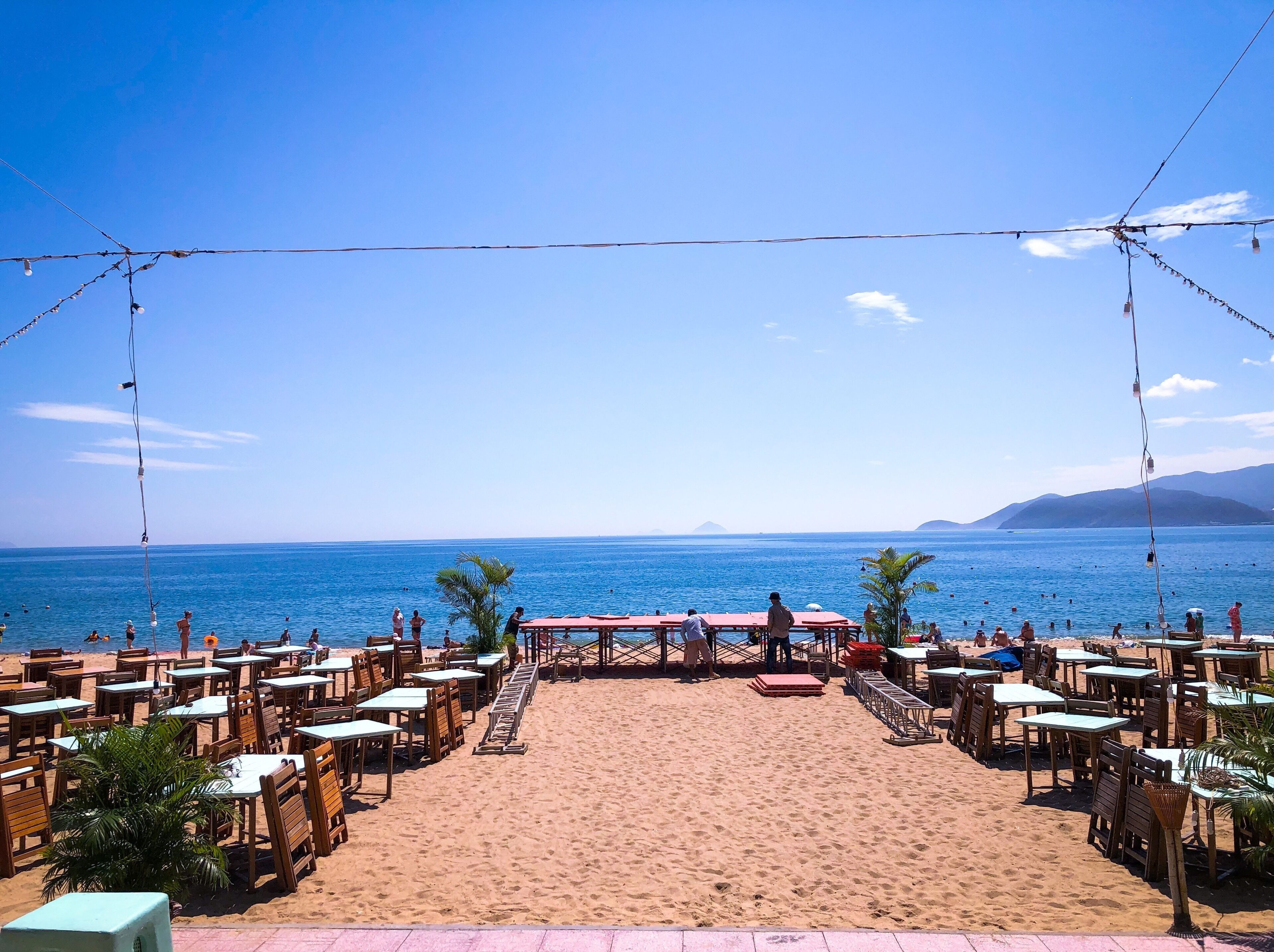 A beachside restaurant with tables and chairs facing the ocean.