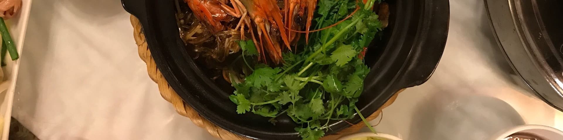 A table with various dishes including shrimp, fried items, and a bowl of peanuts.
