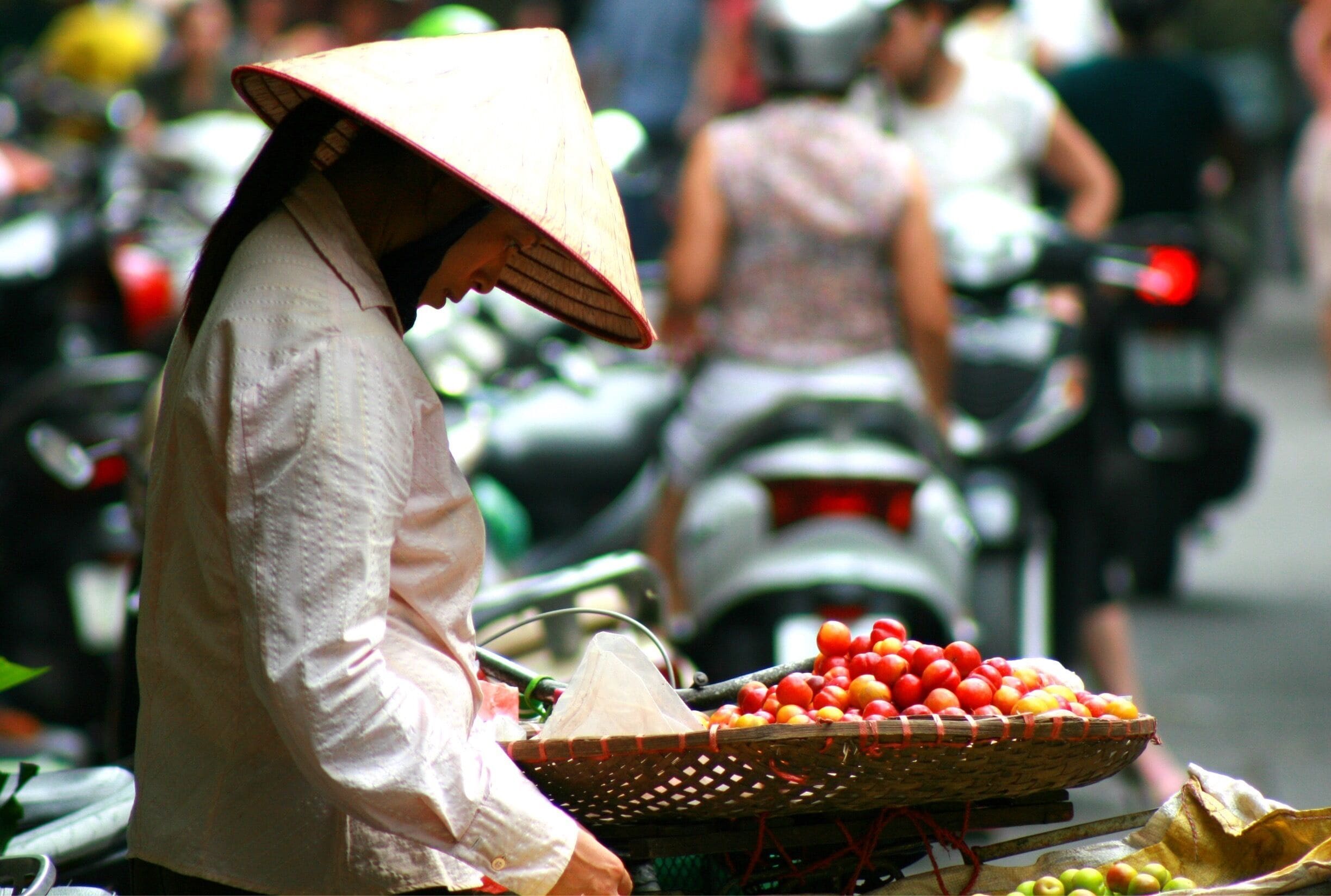 Vendedor oferecendo frutas em um mercado de rua movimentado.