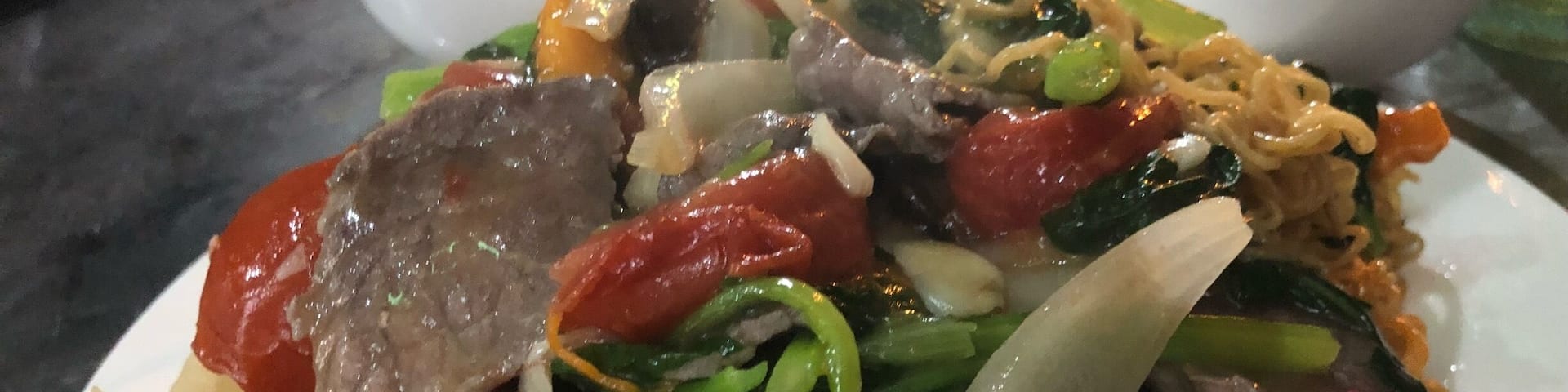 A plate of stir-fried noodles with vegetables and meat.