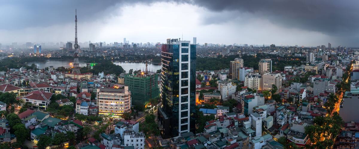 A cityscape with a prominent tower, a river, and a cloudy sky.