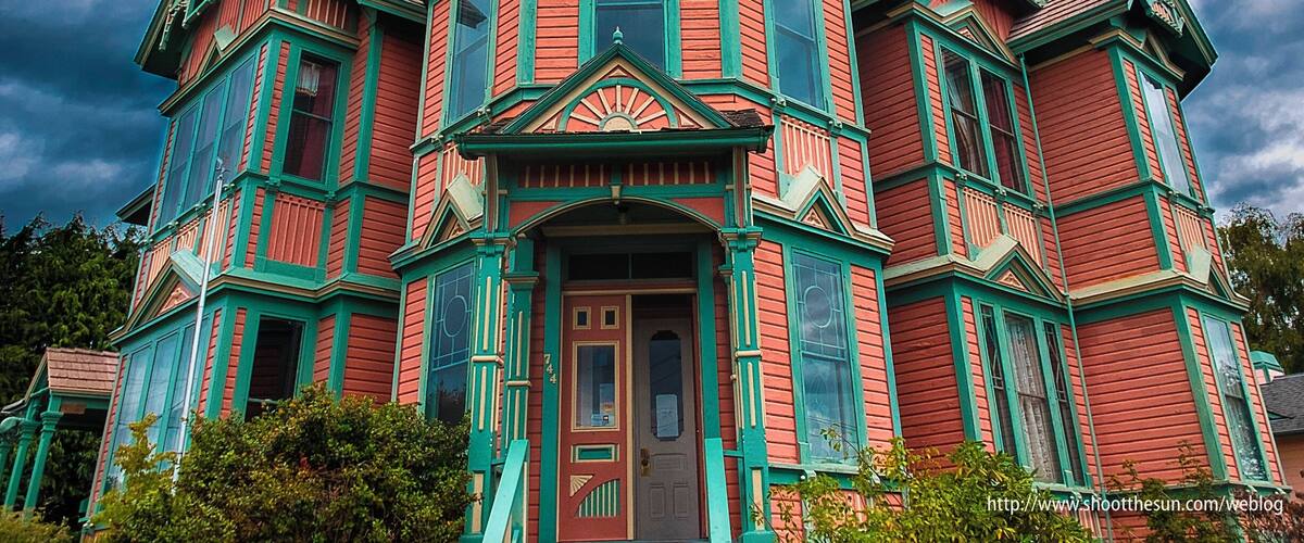 An inveterate fantasm purportedly haunts this house, or at least one of its windows.
When viewed just right from about one spot on the entire planet, the first dark window you see to the right of the central structure appears to reveal a woman sitting in her chair.
To the more jaded eye, it would seem that a large flaw in the ancient glass happens to line up very nicely with a large, stuffed chair directly behind the window.
No matter.  People come from miles around to scare the bejeezus out of themselves by lining up precisely where the apparition can see them and shrieking in delight.
However, few of them will actually stay at the "boutique hotel" contained within.  Which is probably why the owner is looking to sell it.
If you like company, but are not overly fond of money, you might drop by and make him an offer.