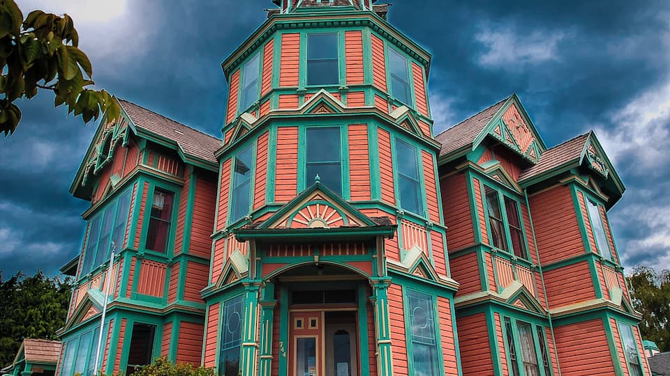 An inveterate fantasm purportedly haunts this house, or at least one of its windows.
When viewed just right from about one spot on the entire planet, the first dark window you see to the right of the central structure appears to reveal a woman sitting in her chair.
To the more jaded eye, it would seem that a large flaw in the ancient glass happens to line up very nicely with a large, stuffed chair directly behind the window.
No matter. People come from miles around to scare the bejeezus out of themselves by lining up precisely where the apparition can see them and shrieking in delight.
However, few of them will actually stay at the "boutique hotel" contained within. Which is probably why the owner is looking to sell it.
If you like company, but are not overly fond of money, you might drop by and make him an offer.