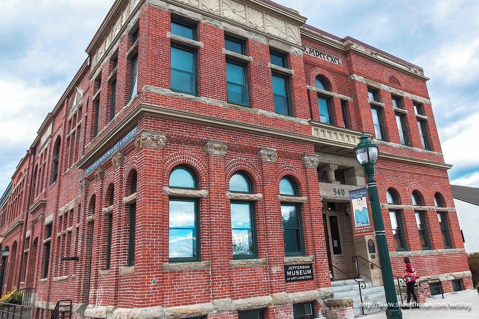 A red brick building with arched windows and a sign reading "Jefferson Museum of Art & History".