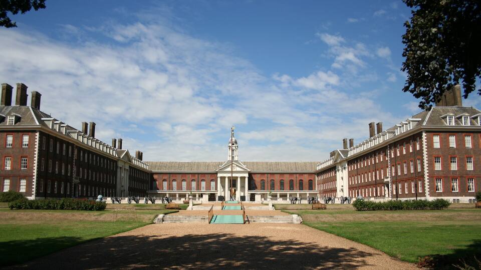 A large, symmetrical building with a central pavilion and a clear sky.
