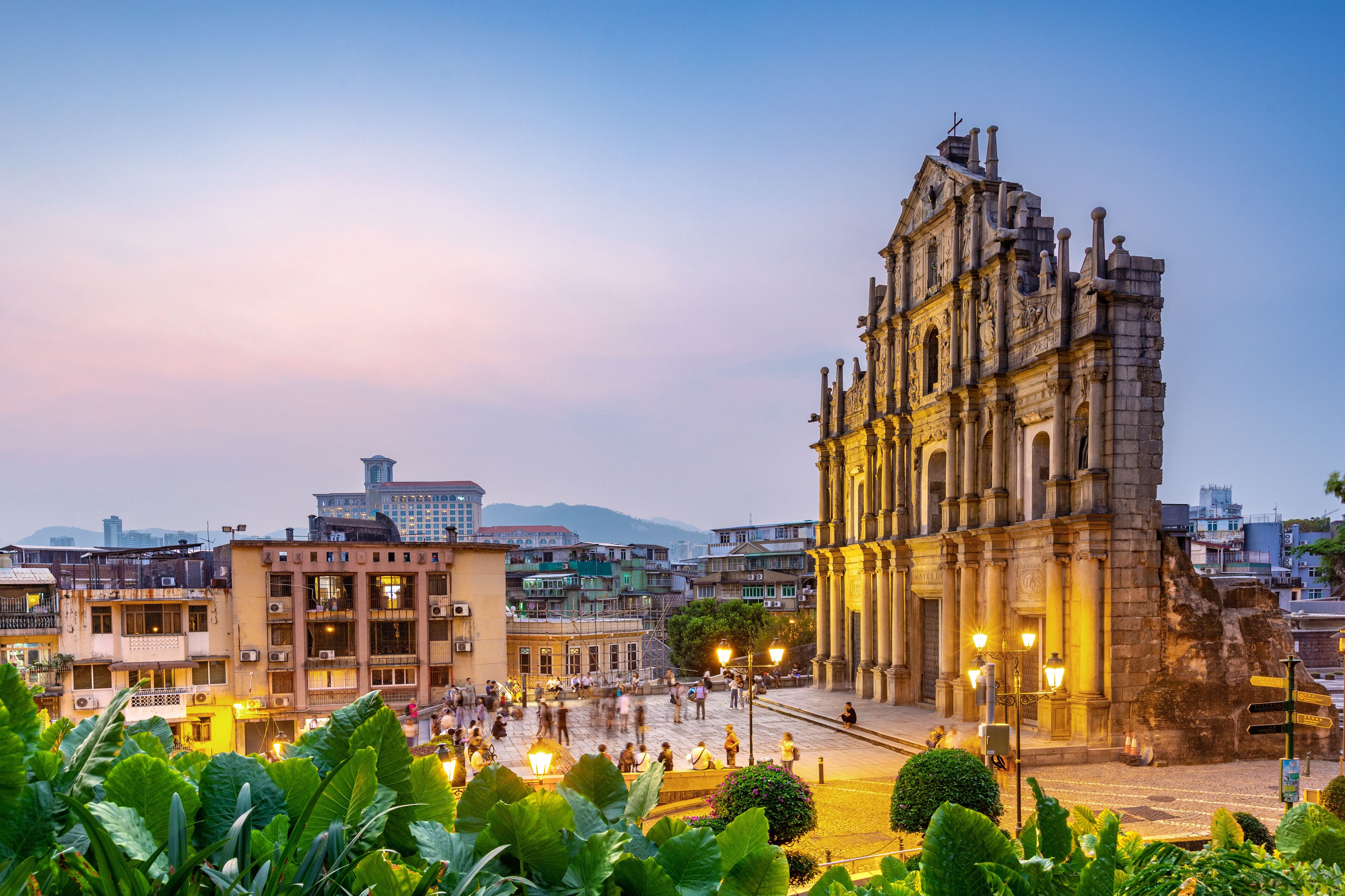 A historic cathedral with intricate architecture, a bustling square with people, and surrounding buildings.