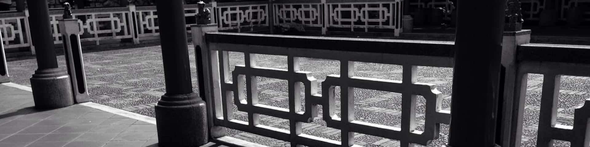 A tiled walkway with a decorative fence and columns.