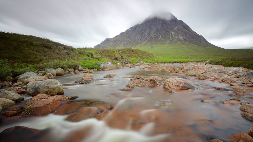 A river flowing through a rocky landscape with a mountain in the background.
