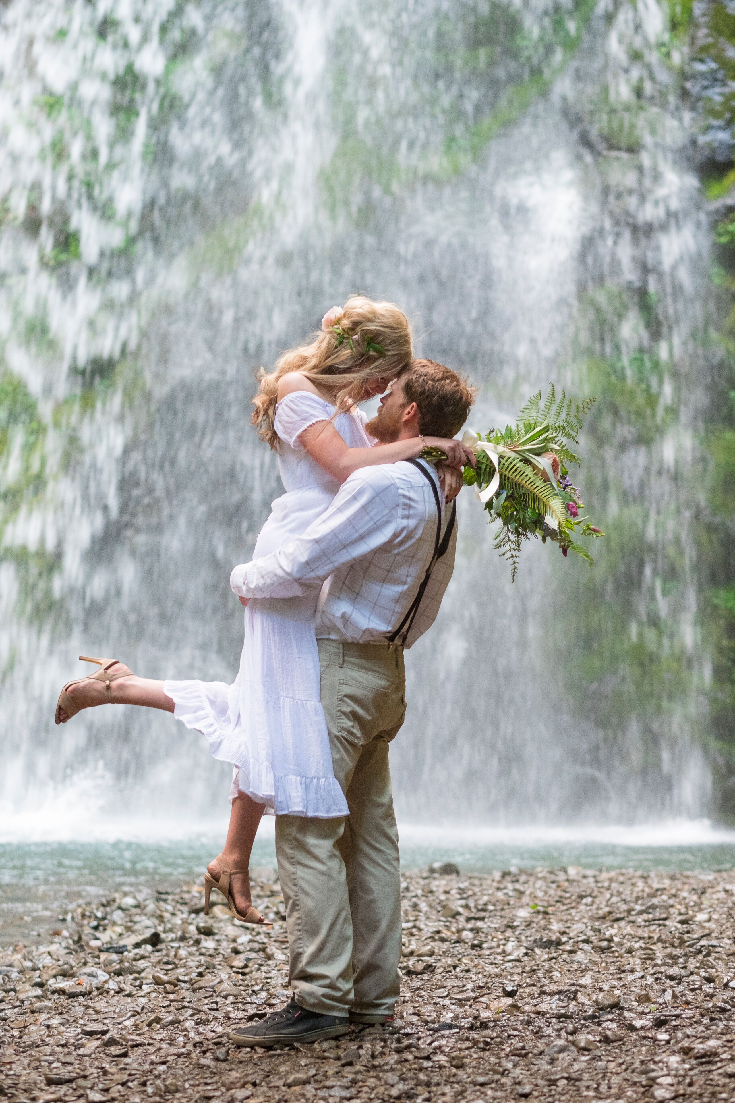 Bride and groom embracing near Fall Creek Falls waterfall, North Umpqua National Forest, Oregon, USA