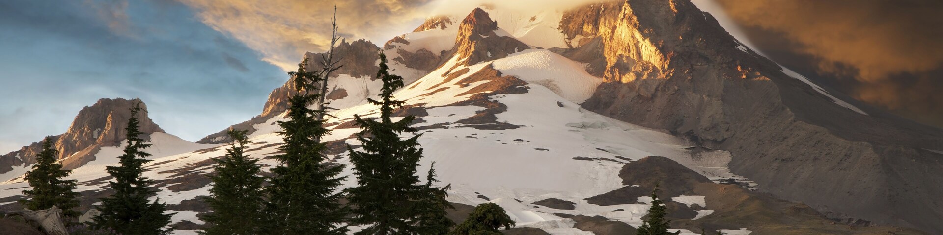 Snow covered Mt. Hood, near Portland, Oregon. Cloud hanging on summit. Amber sunset cloud foreshadows impending storm.