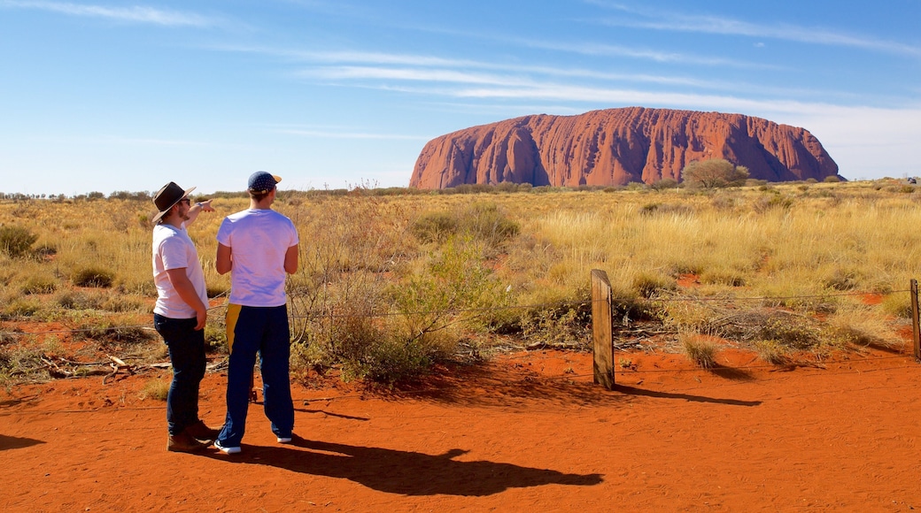 Uluru ofreciendo vistas al desierto y vistas de paisajes y también una pareja