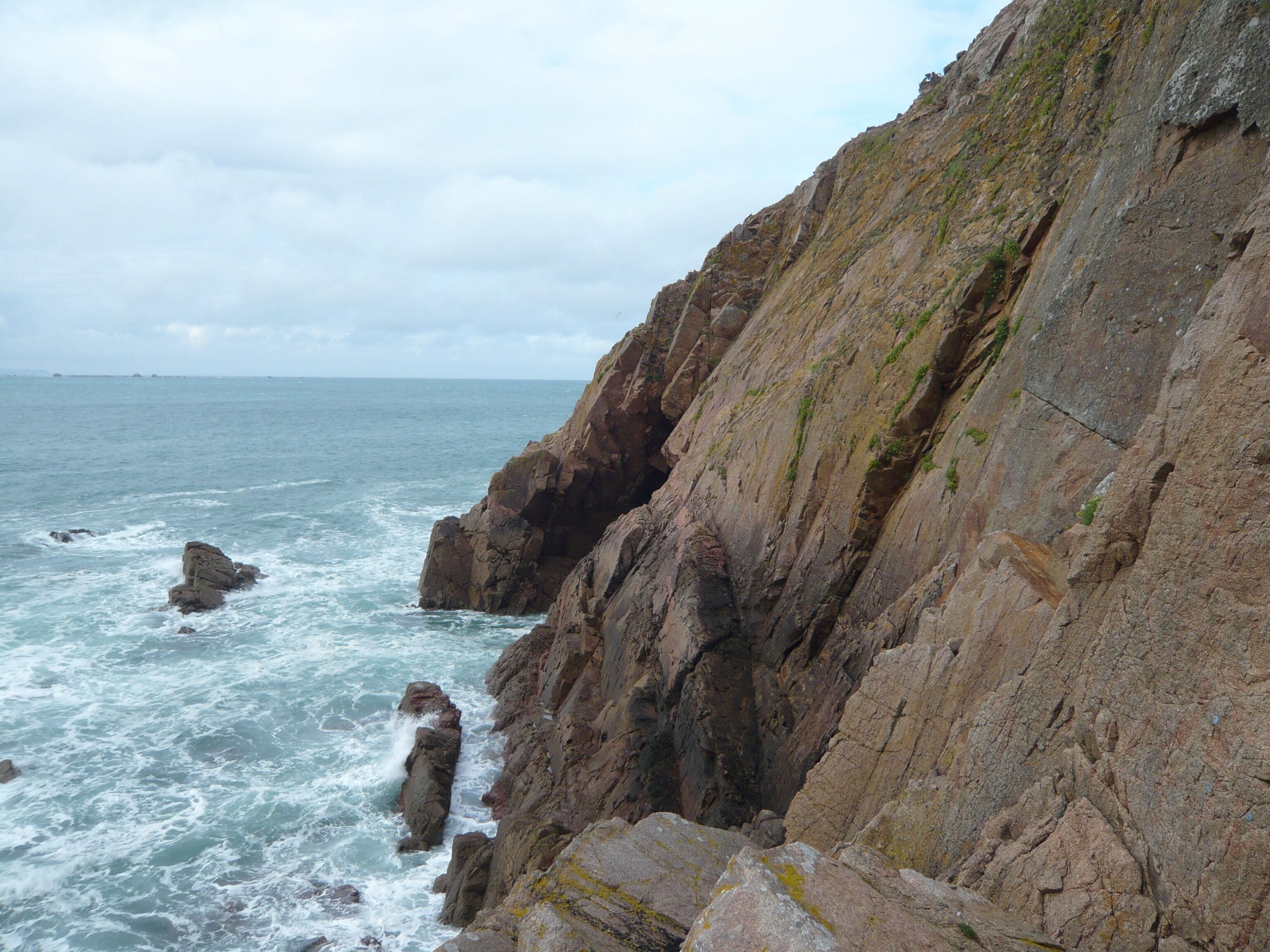A rocky coastline with waves crashing against the cliffs.