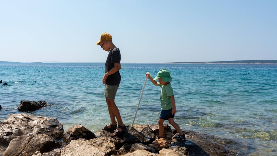 A rocky shoreline with clear blue water.