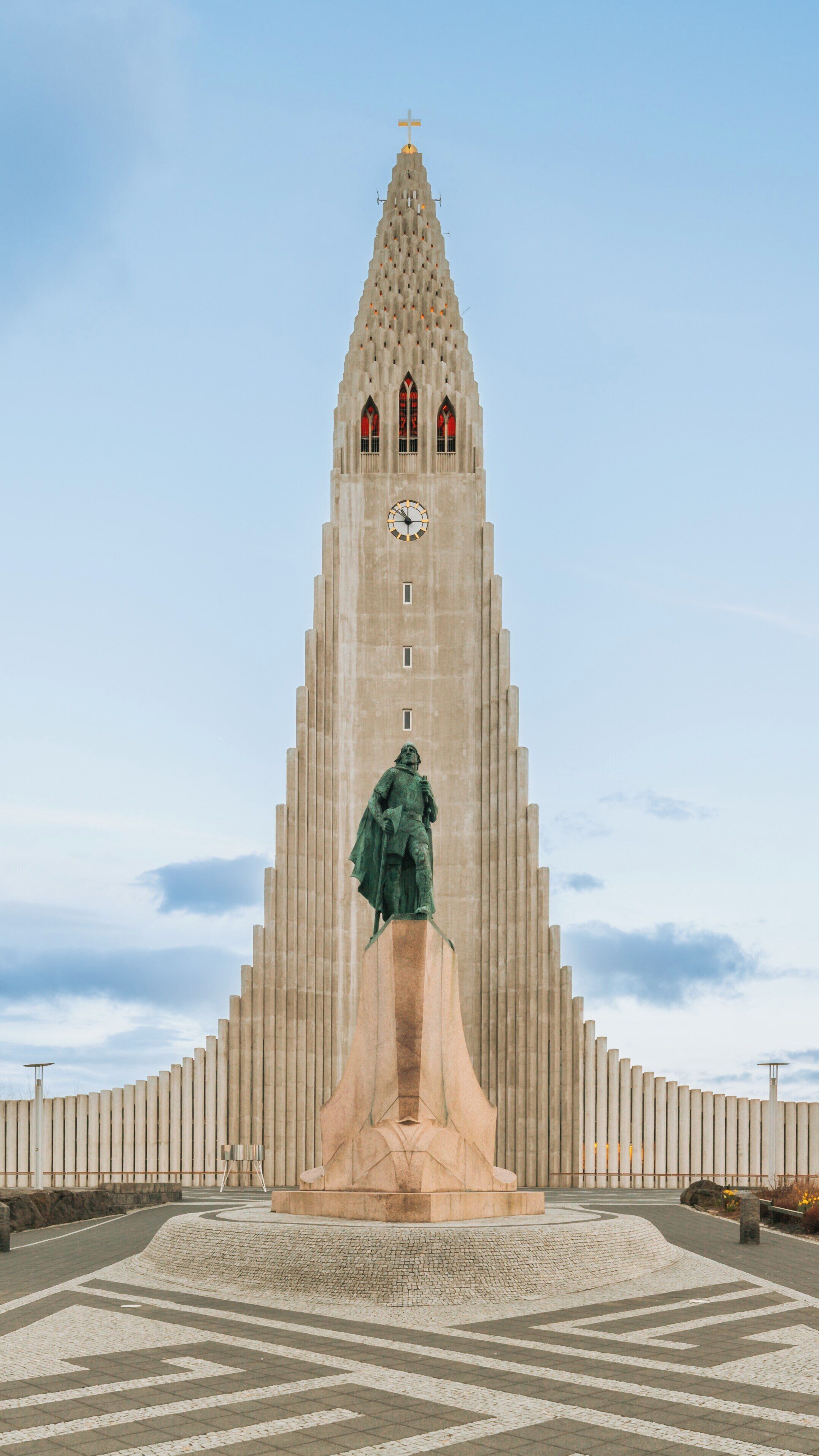 Hallgrimskirkja stands majestically in Reykjavik, showcasing its unique architecture against a serene sky as visitors admire its beauty