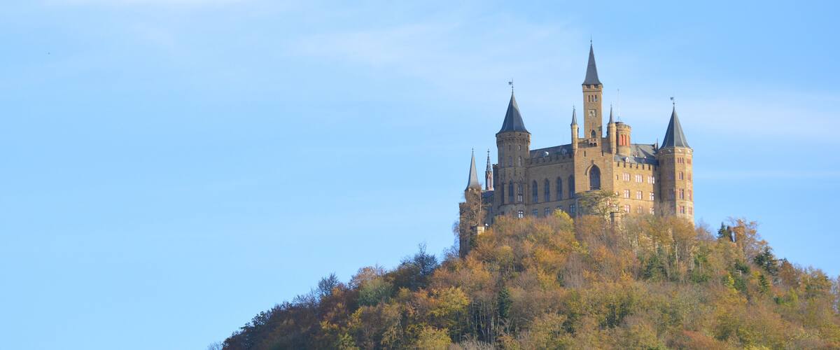 A castle on a hill with autumn foliage.