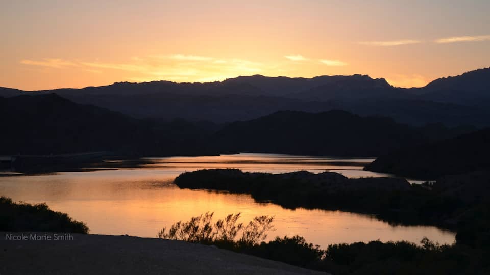 Bullhead City showing a hot spring, mountains and a sunset