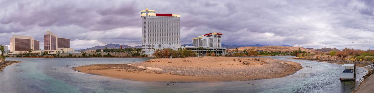 Colorado River Landscape Series, Laughlin skyline and buildings with dramatic stormy cloudscape over the curving river and sand island of a wildlife sanctuary in Laughlin, Nevada, USA