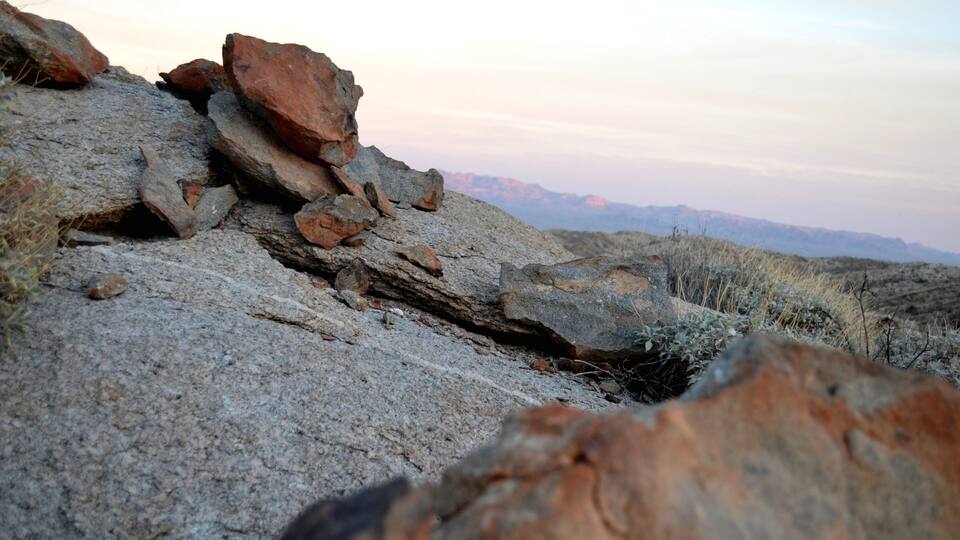 A rocky landscape with large boulders and sparse vegetation.