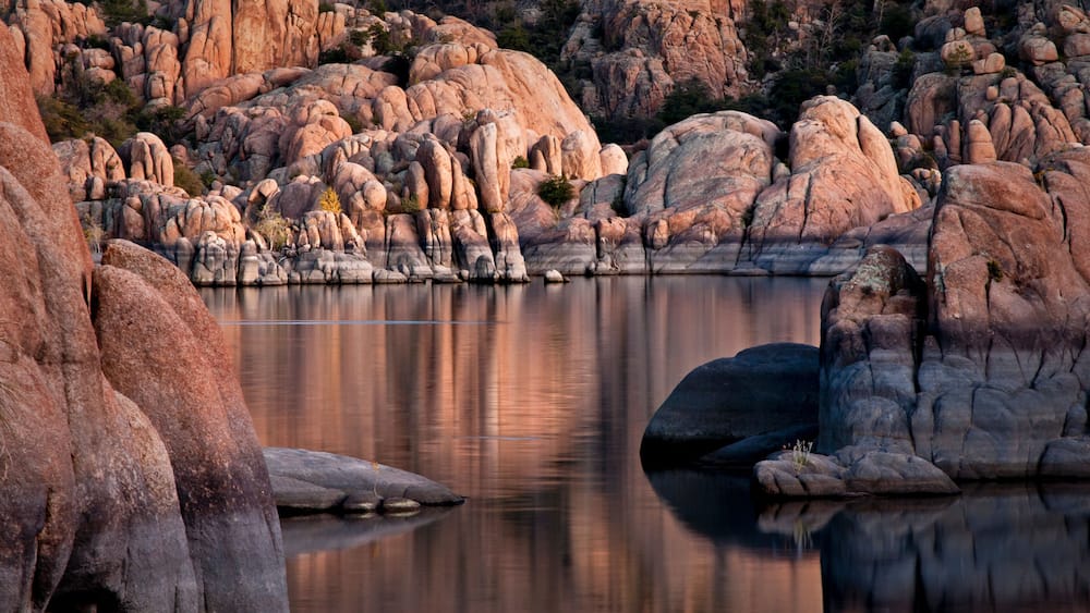 The granite rock formations of the Granite Dells area of Watson Lake glow in the twilight of a fading southwestern sunset. Prescott, Arizona.