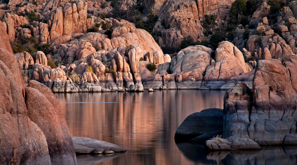 The granite rock formations of the Granite Dells area of Watson Lake glow in the twilight of a fading southwestern sunset. Prescott, Arizona.